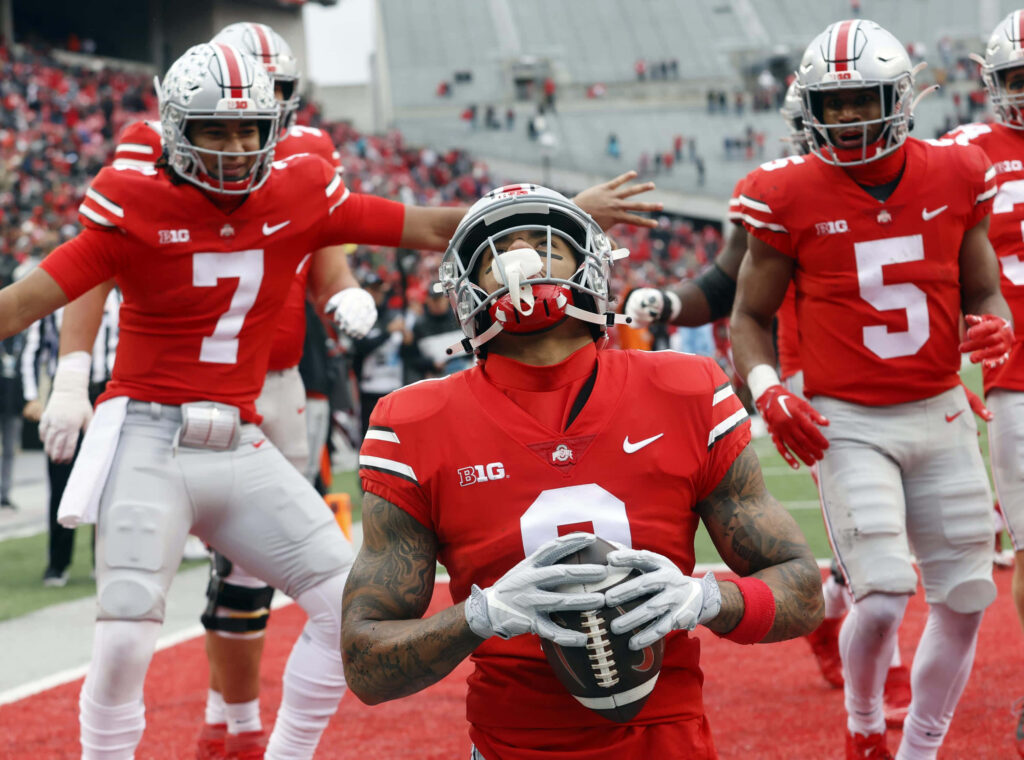 Ohio State football players celebrate touchdown in end zone with cheering crowd wallpaper background