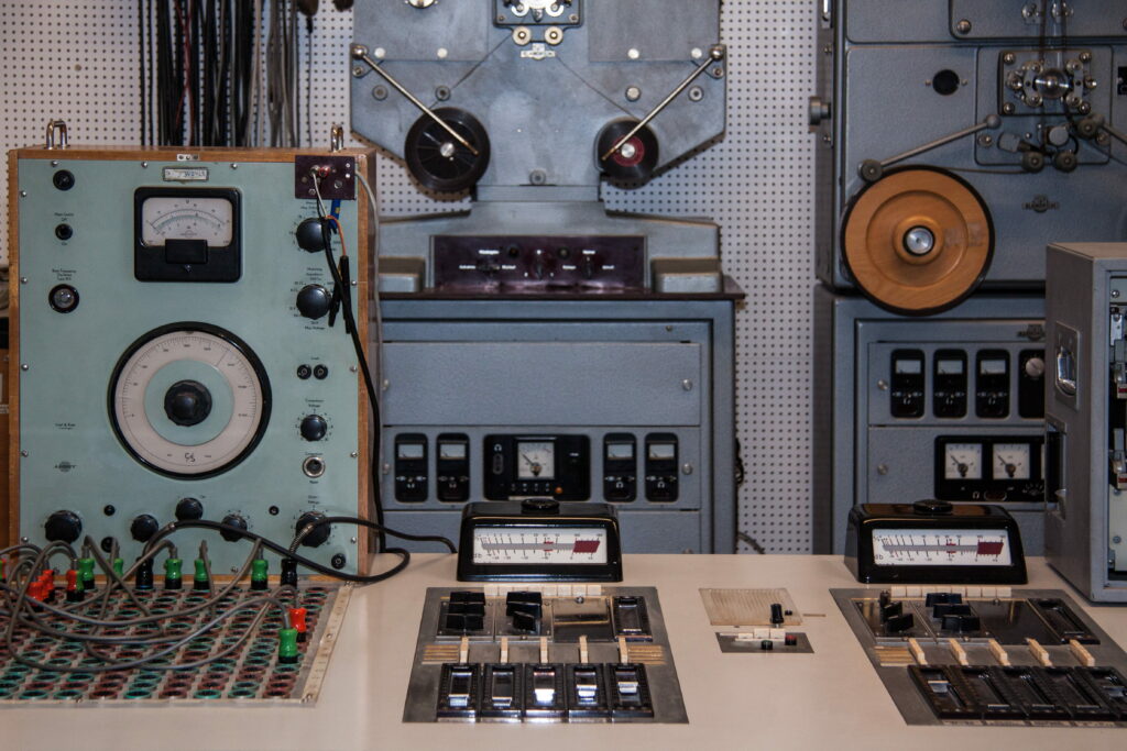 Vintage Vibes: Assorted 1960 Analog Devices Turned on in Old Music Studio with Synthesizer on Wallpaper Background