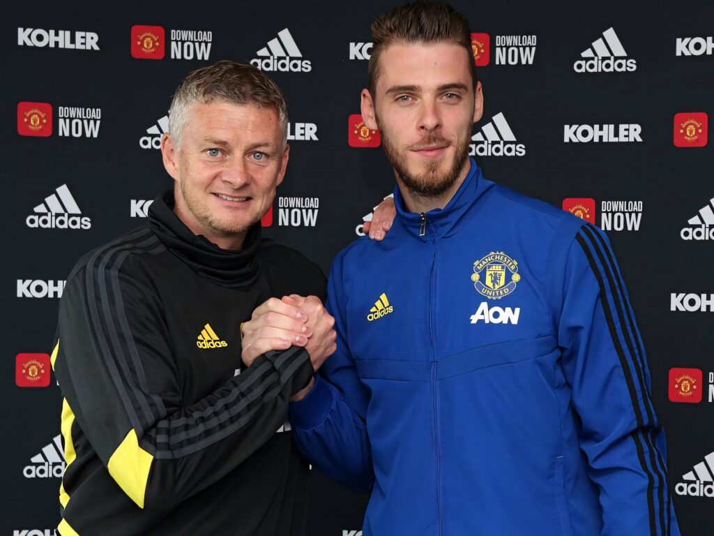 Ole Gunnar Solskjær and David de Gea in Manchester United tracksuits posing confidently together Wallpaper