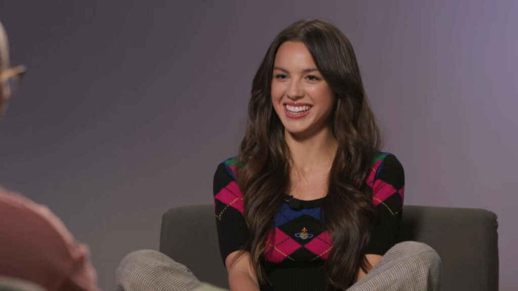 Olivia Rodrigo Wallpaper: Cheerful Interview Smiles in Style