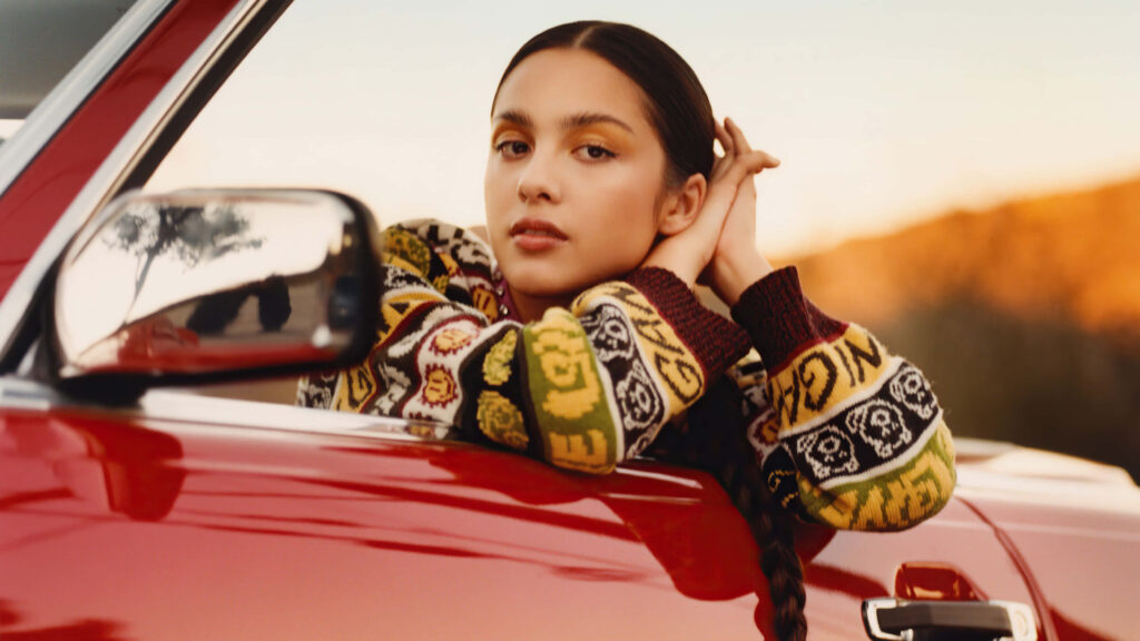 Olivia Rodrigo Confidently Posing in Stylish Car Window Wallpaper