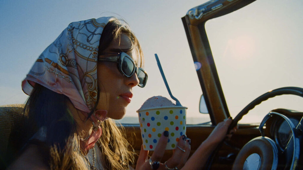 Olivia Rodrigo Relaxing in Convertible with Ice Cream: Stylish Wallpaper