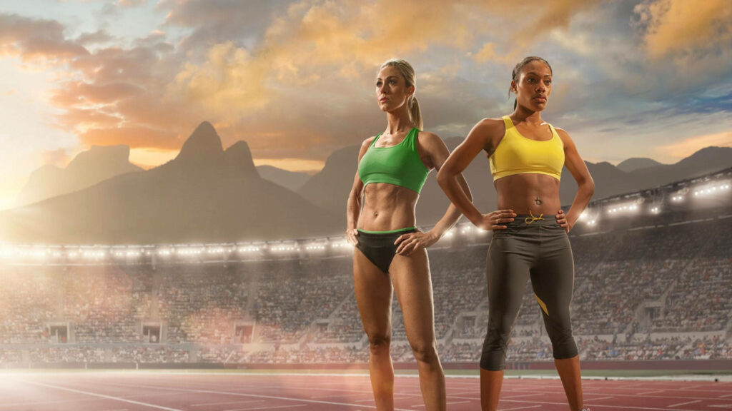 Empowered Athletes at Sunset: Olympic Spirit Wallpaper Background