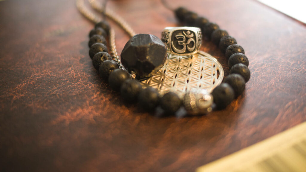 Om Beaded Bracelet: A Symbol of Peaceful Serenity - Beaded Bracelet Wallpaper Featuring the Om Symbol on a Stunning Background Photo