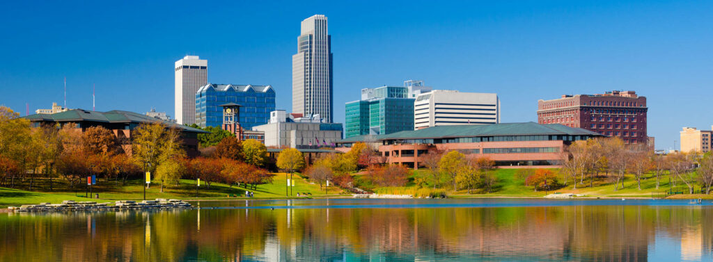 Vibrant Omaha Skyline Panorama: Autumn Trees & Water Reflection Wallpaper
