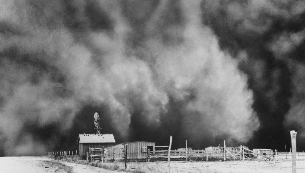 Ominous dust storm over rural farmhouse and windmill black and white plains wallpaper background