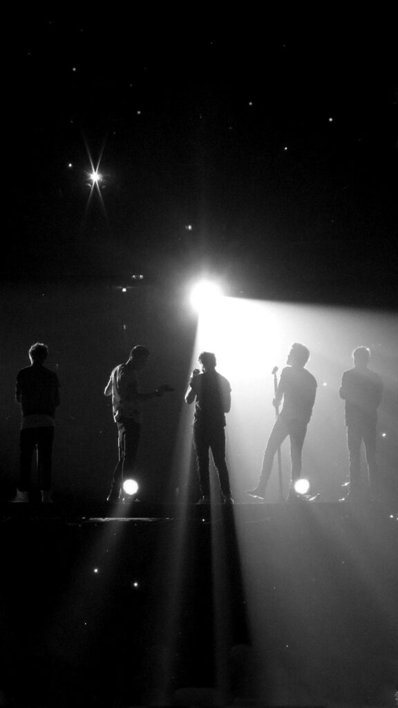 Ethereal Backstage Glow: Captivating One Direction Members in Spotlight Wallpaper