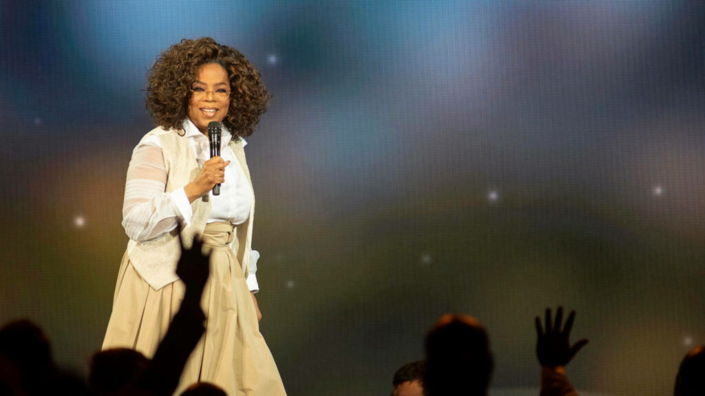 Oprah Winfrey Onstage: Inspiring Audience Moment Wallpaper Background