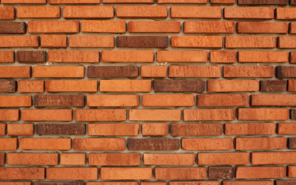 Vibrant & Textured: A Captivating Perspective of Orange Brick Wall in QHD Wallpaper