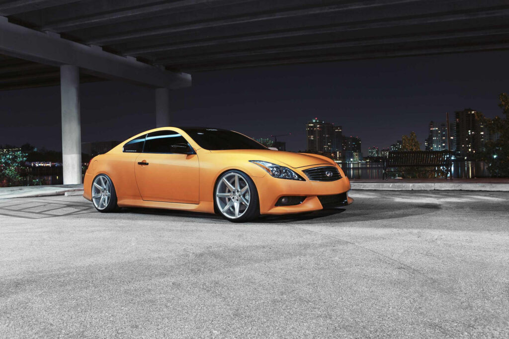 Stylish Orange Infiniti G37 Wallpaper in Urban Night Scene