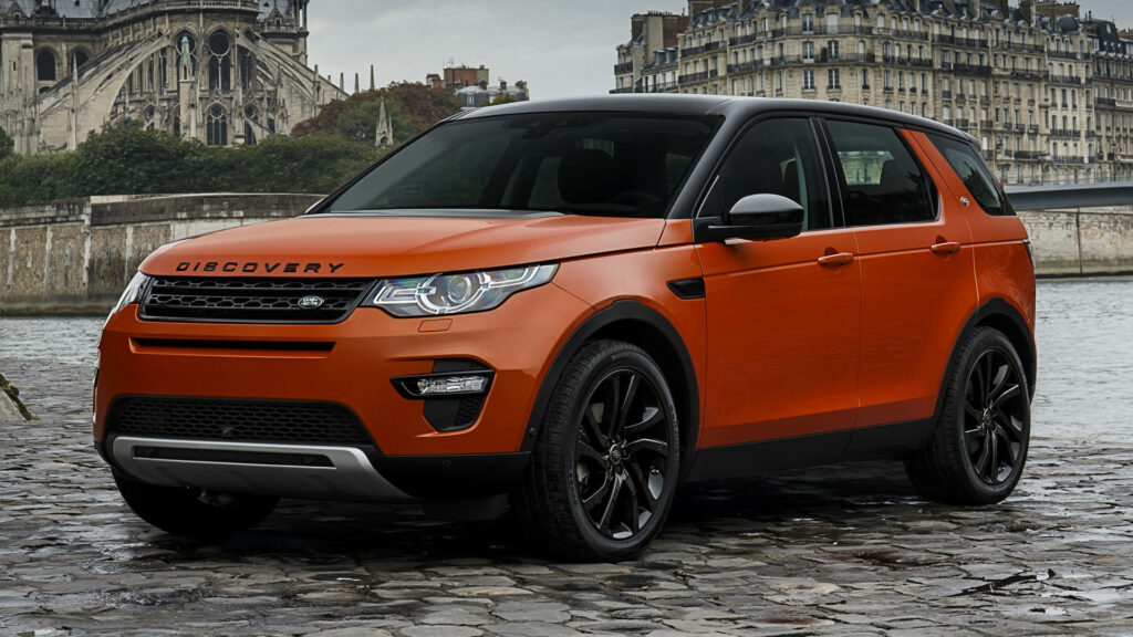 Orange Land Rover Discovery Wallpaper for iPhone: Urban Cobblestone Scene