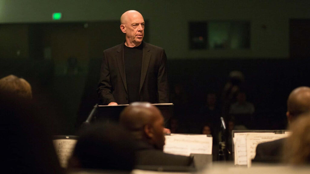 Majestic Orchestra Conductor at Podium - Dimly Lit Wallpaper Background