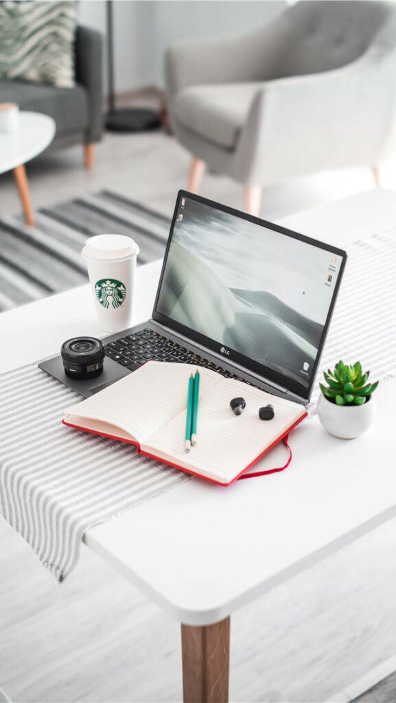 The Minimalist Workspace: A White Desk with Refreshing Green Succulent, Essential Tools, and a Dash of Caffeine Wallpaper