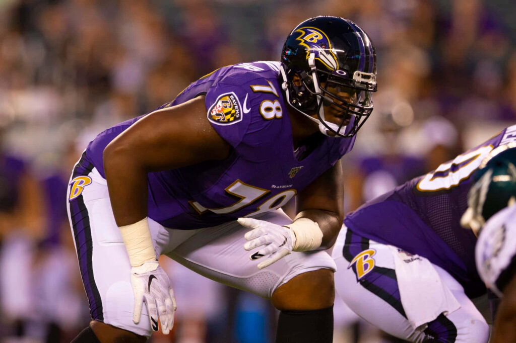 Orlando Brown Jr Baltimore Ravens offensive tackle showing strength and focus on football field Wallpaper