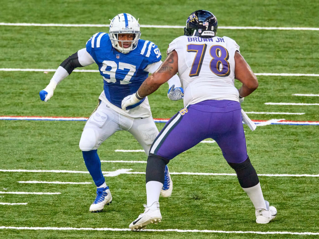 Orlando Brown Jr Baltimore Ravens versus Indianapolis Colts defender intense NFL action wallpaper