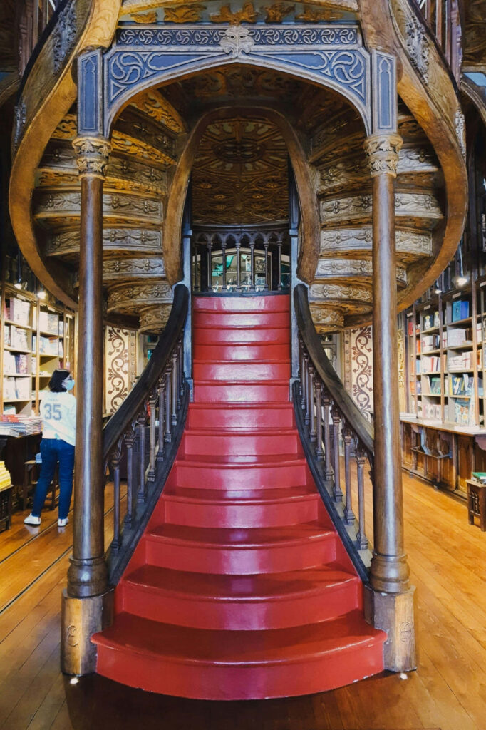Ornate Adelaide State Library staircase with intricate woodwork vibrant red steps and bookshelves Wallpaper