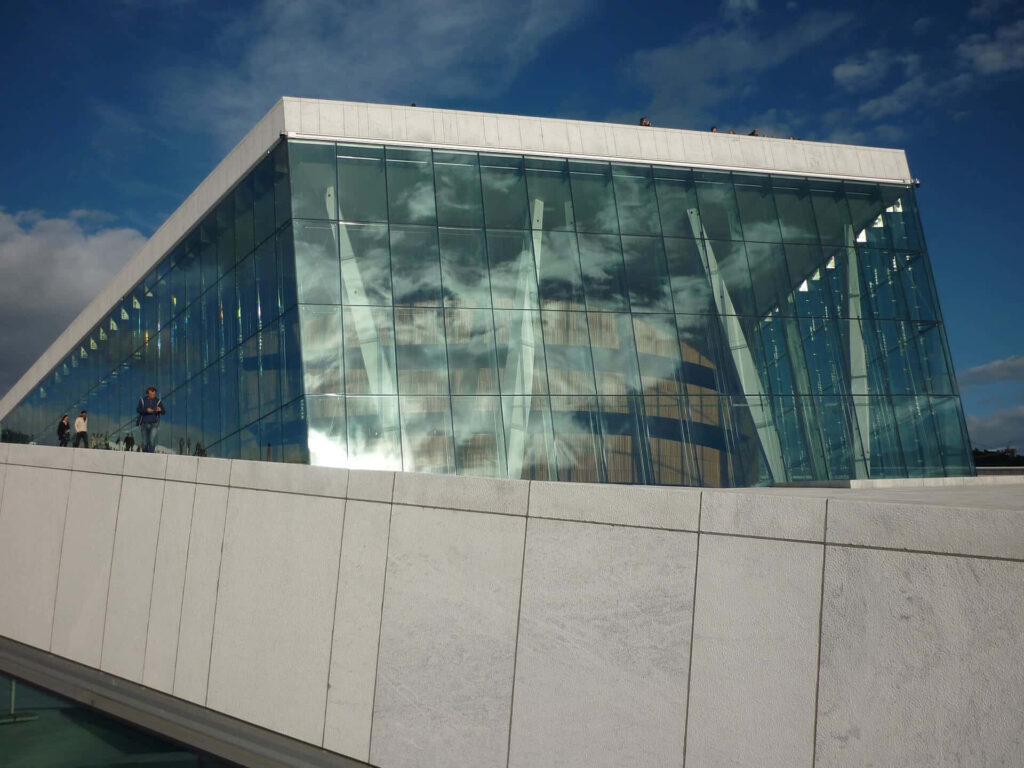 Oslo Opera House modern architecture with glass façade and white stone against blue sky wallpaper
