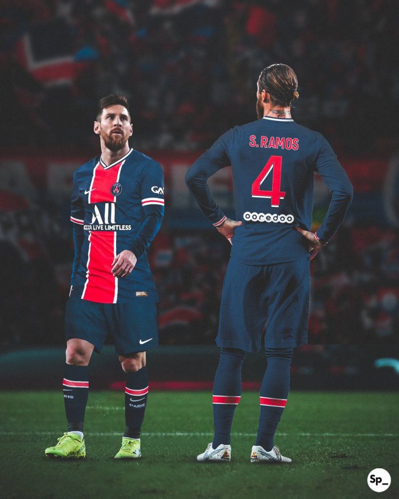 PSG wallpaper featuring legends Lionel Messi and Sergio Ramos in navy blue kits on pitch