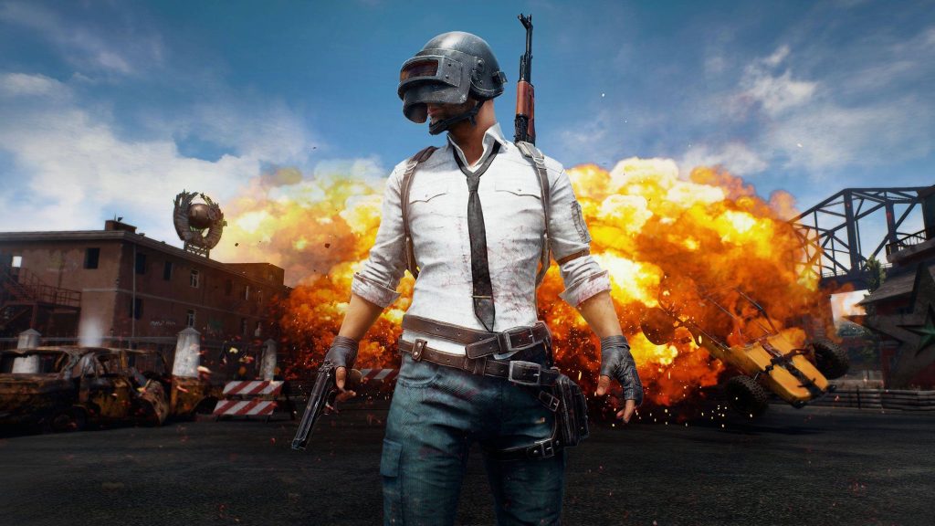 PUBG survivor in Level 3 helmet ready for battle with explosion on Erangel map wallpaper