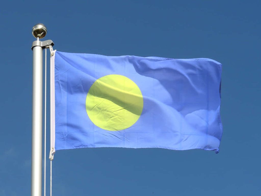 Palau national flag waving bright blue sky yellow circle metallic flagpole patriotic wallpaper
