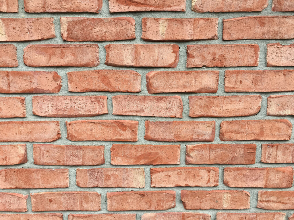 Pale Red Brick Texture Wallpaper: Rustic Design with Irregular Shapes