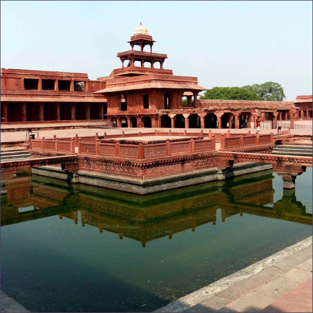 Panch Mahal Fatehpur Sikri red sandstone palace reflected in Anup Talao pool historic Mughal architecture Wallpaper