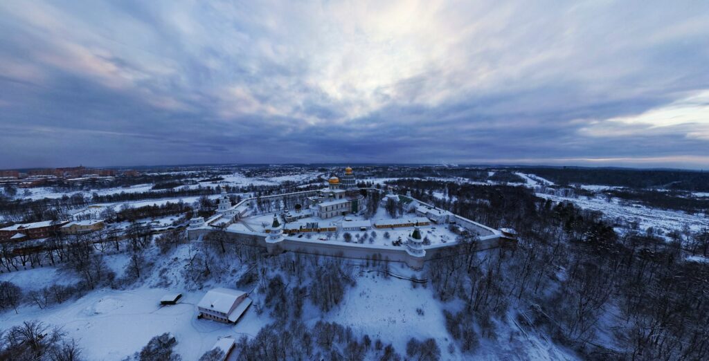 Panoramic winter view of Jerusalem fortified walls with domed temples under cloudy sky wallpaper