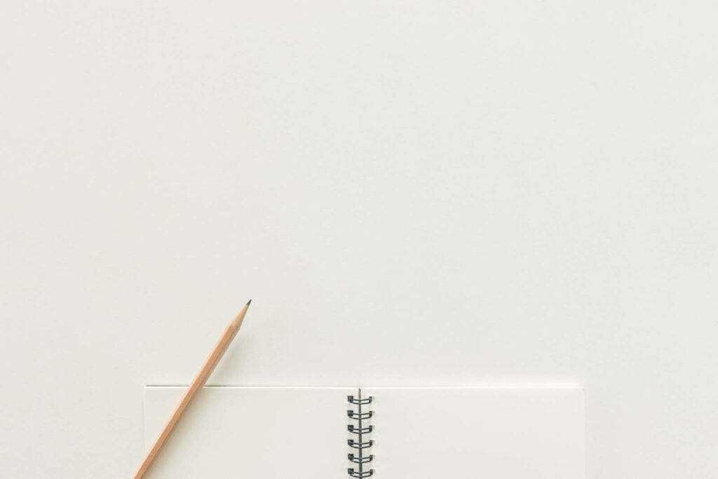 Blank Canvas: A Notebook Unveiling Crisp White Paper Texture, Accompanied by an Upward-Facing Pencil on a Paper Texture Background Wallpaper