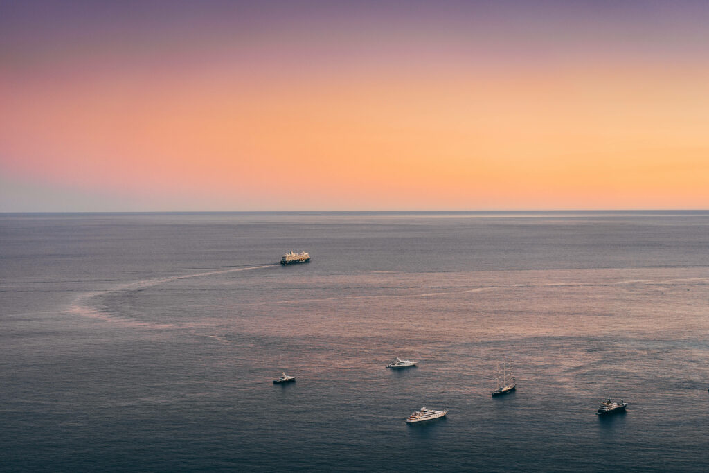 Serene Majestic Expanse: Breathtaking Sea HD Background Showcasing Vast Waters and Distant Yachts Wallpaper