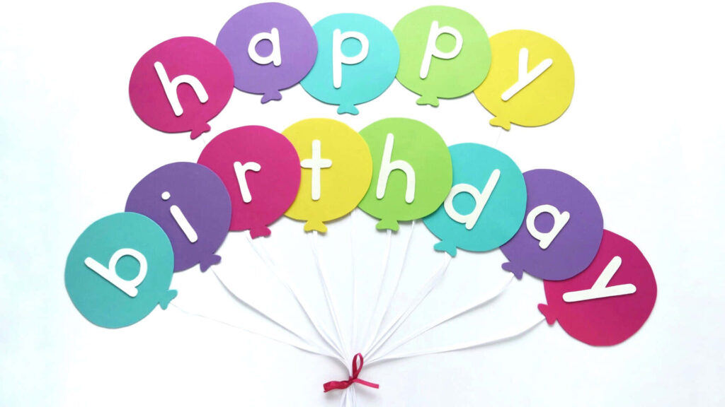 Vibrant Happy Birthday balloon banner wallpaper with colorful paper-cut balloons and pink ribbon