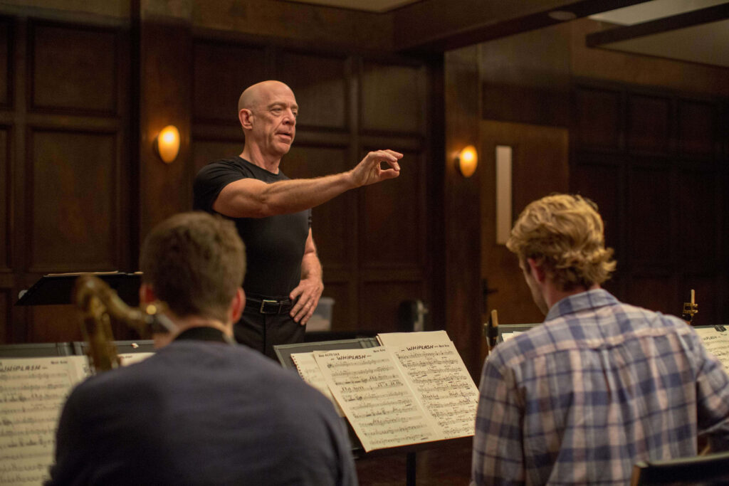 Focused Music Rehearsal: Passionate Instructor & Musicians in Action Wallpaper