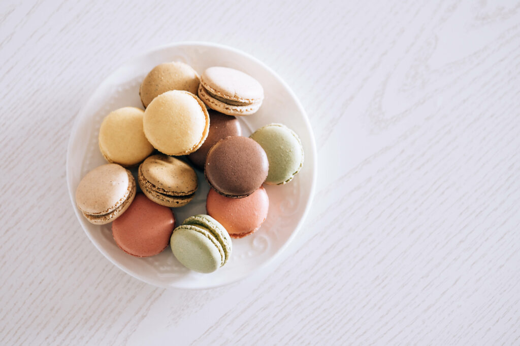 Pastel Aesthetic Wallpaper: Colorful Macarons on Textured White Wood
