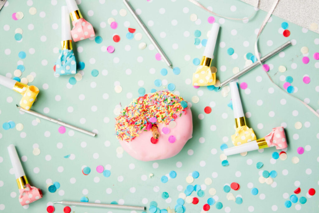 Cheerful Pastel Birthday Wallpaper with Sprinkled Doughnut & Confetti
