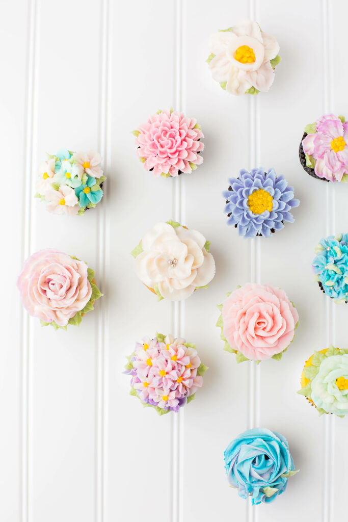 Pastel Cupcake Wallpaper with Floral Icing on Textured White Background