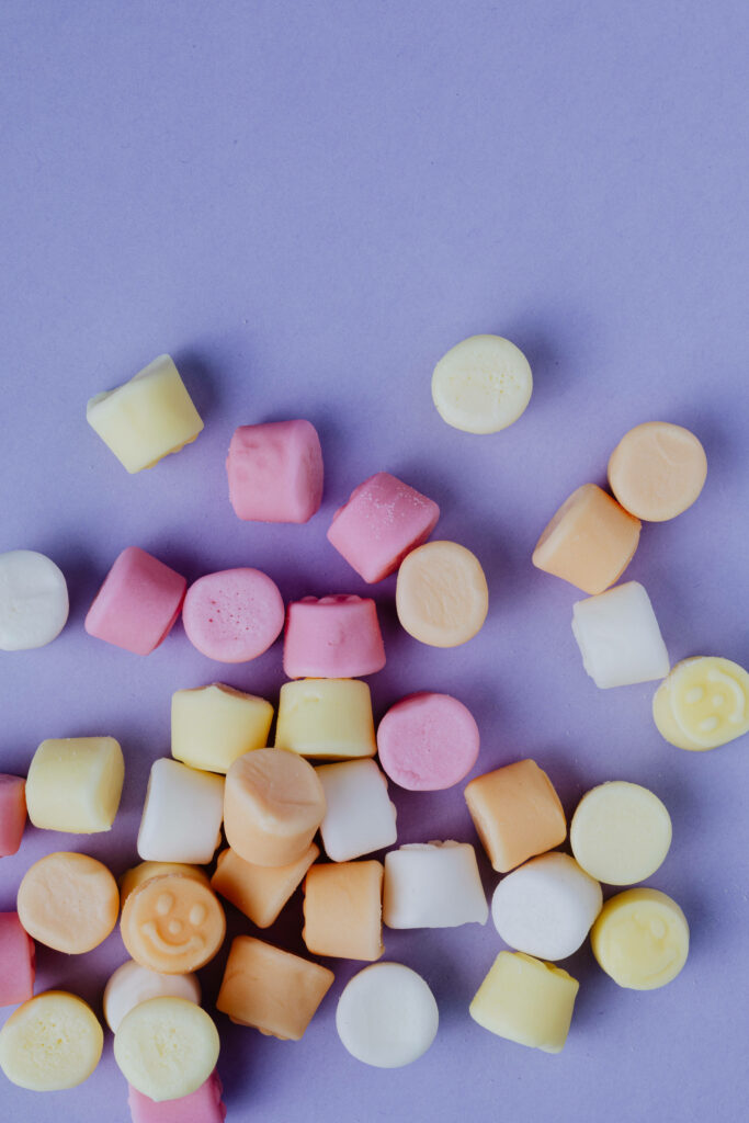 Simplistic Display: Pastel Marshmallows Resting on Serene Purple Background Wallpaper