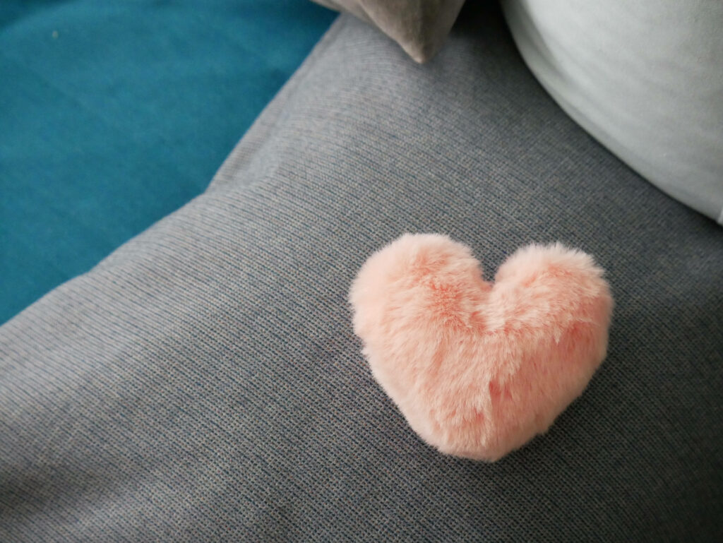 Love Takes Center Stage: A Soft Pink Heart Amidst a Serene Turquoise Setting Wallpaper