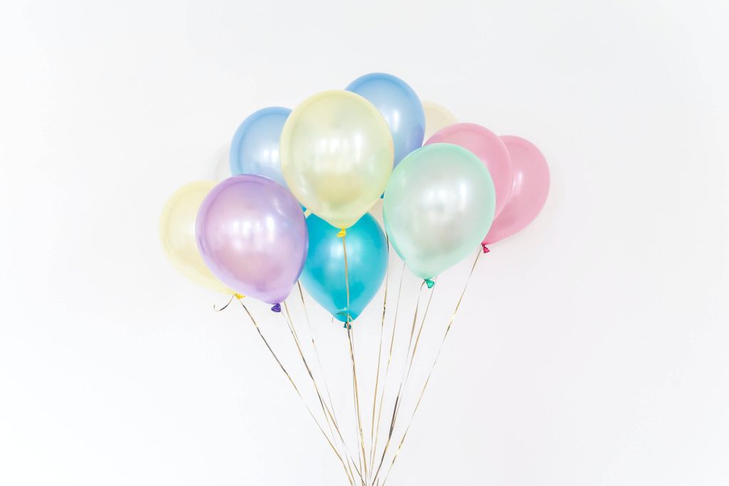 Pastel rainbow balloons on white background cheerful desktop wallpaper for bright workspace