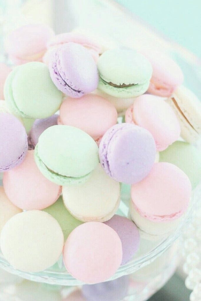 Pastel rainbow French macarons close-up in soft pink green and lilac colors wallpaper background