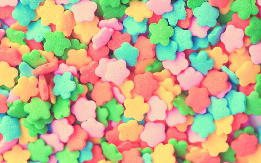 Close up of pastel star-shaped candies wallpaper colorful sweet sugary texture background