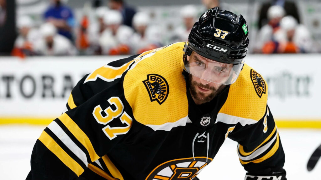 Patrice Bergeron Boston Bruins hockey player in black and gold jersey number 37 on ice action Wallpaper