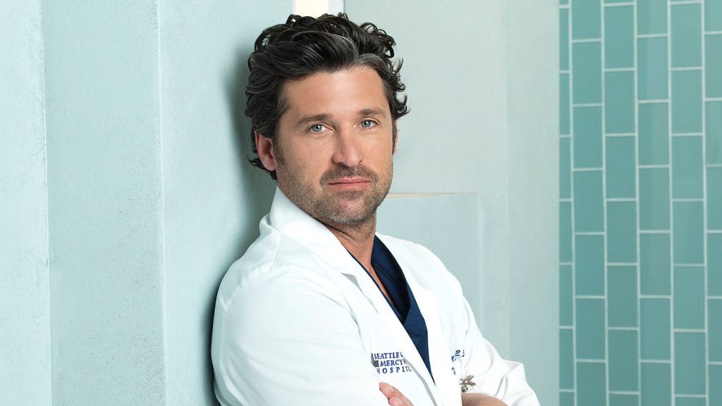 Patrick Dempsey as Dr Derek Shepherd in white coat leaning hospital wall calm expression wallpaper