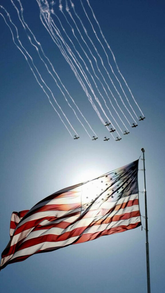 Fighter jets flying in formation over waving American flag clear blue sky patriotic wallpaper