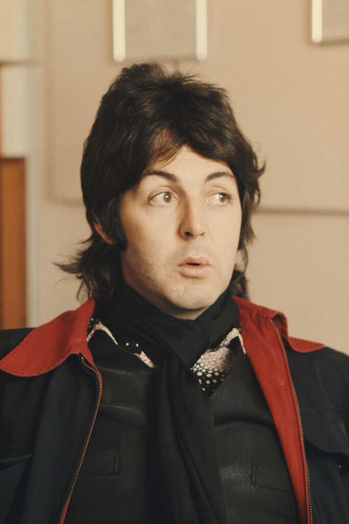Paul McCartney in stylish jacket surprised expression iconic Beatles era wallpaper background