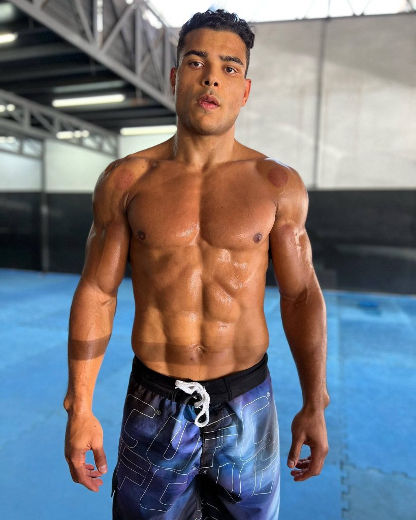 Paulo Costa shirtless UFC fighter showing shredded abs and shoulder cupping marks on gym mat Wallpaper
