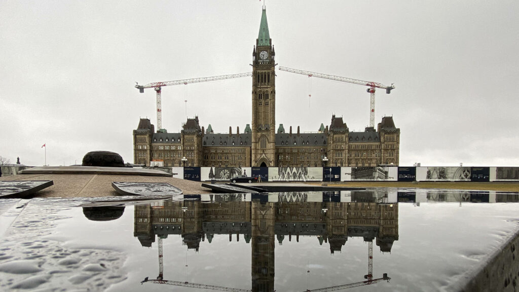 Peace Tower Ottawa Parliament building under overcast sky reflective foreground with construction Wallpaper