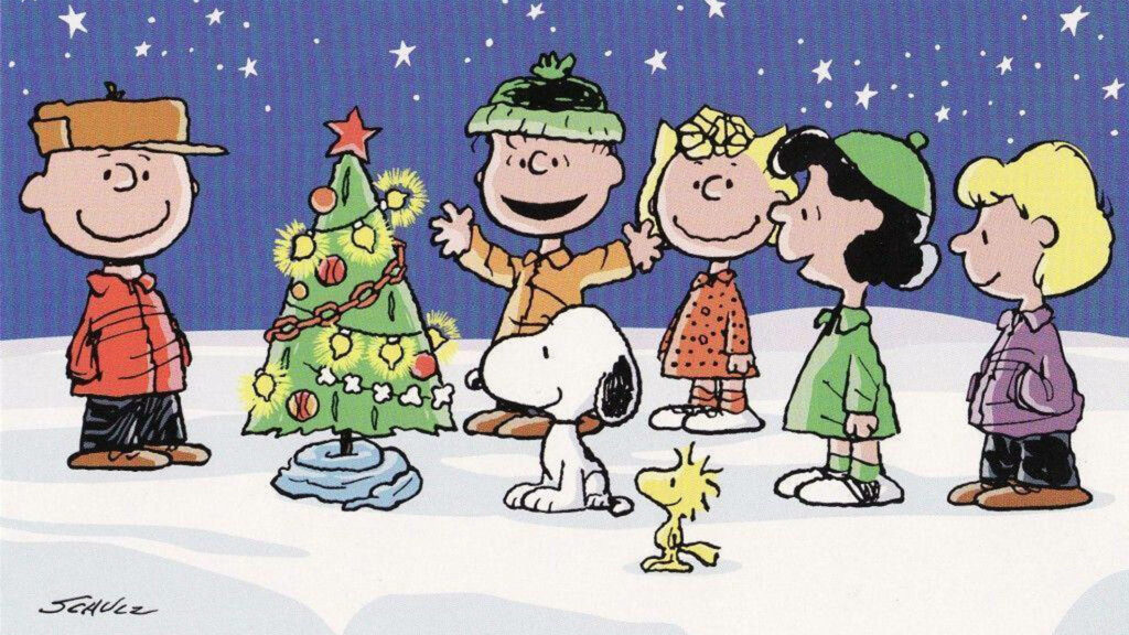 Peanuts Characters Celebrate Christmas by a Decorated Tree in Snow Wallpaper