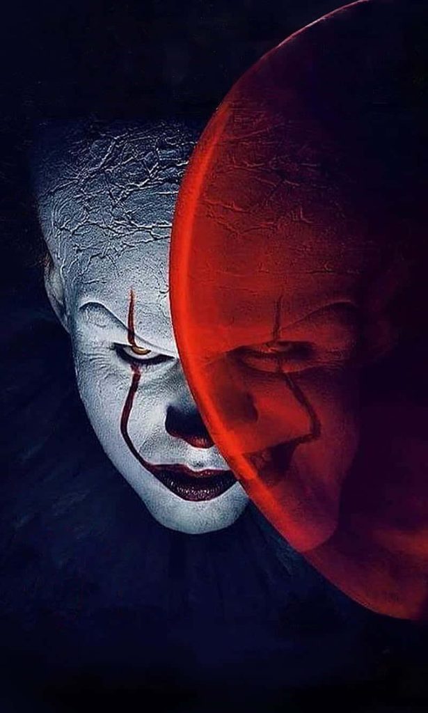 Pennywise clown face with cracked white makeup and red balloon dark horror wallpaper background