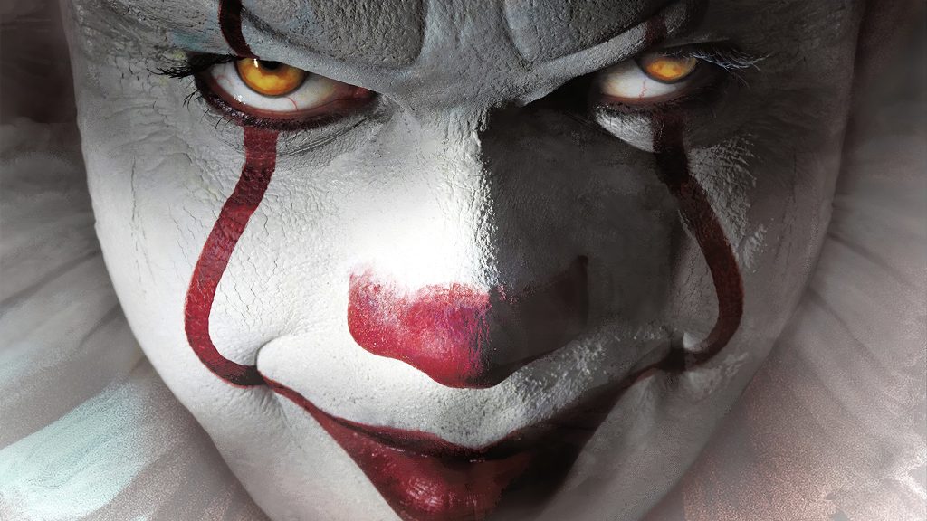 Extreme close-up of Pennywise clown with cracked makeup and piercing yellow eyes horror wallpaper