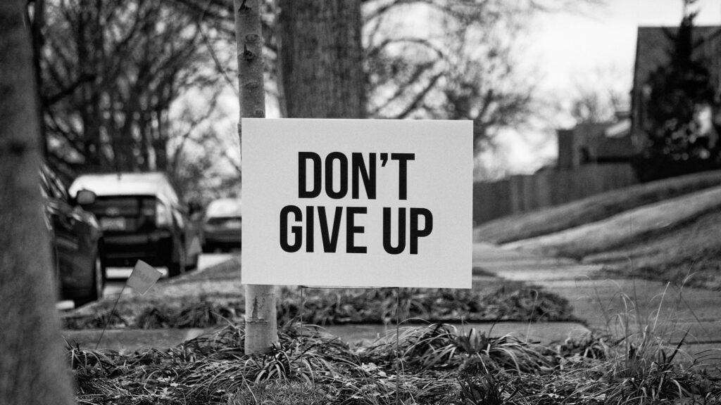 Perseverance in Monochrome: Motivational Laptop Wallpaper Showcasing Resilience on a Grassy Pathway