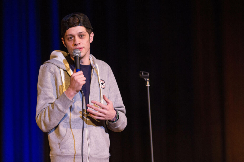 Pete Davidson Standup Wallpaper: Comedian on Stage in Hoodie & Cap